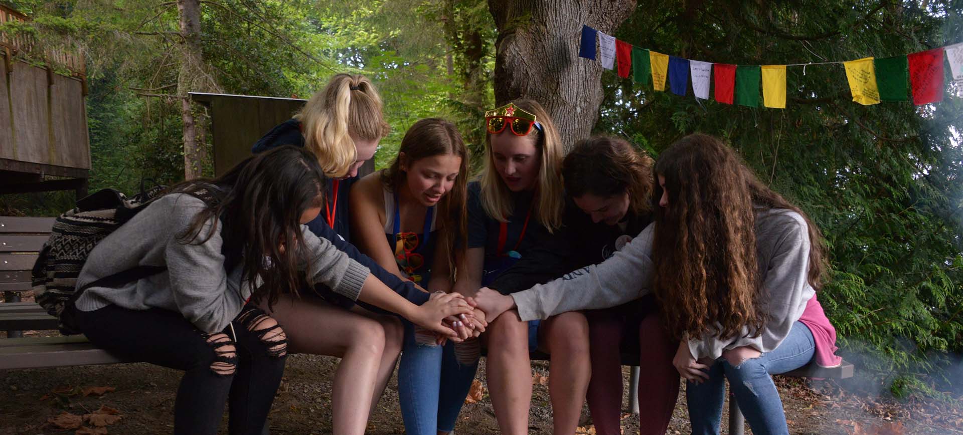 A group of girls hugging at camp
