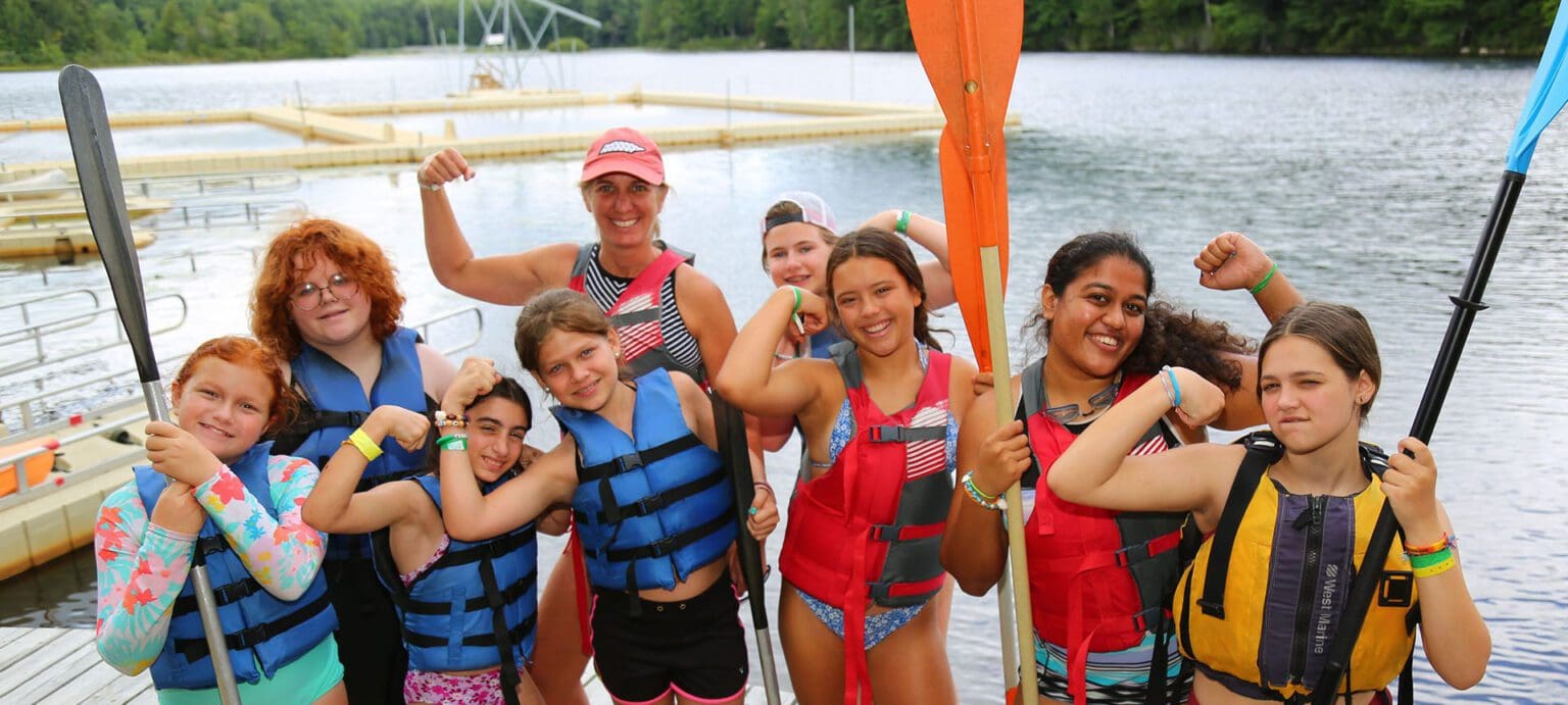 A group of girls hugging at camp