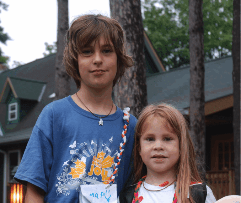 A young boy and girl standing next to each other smiling