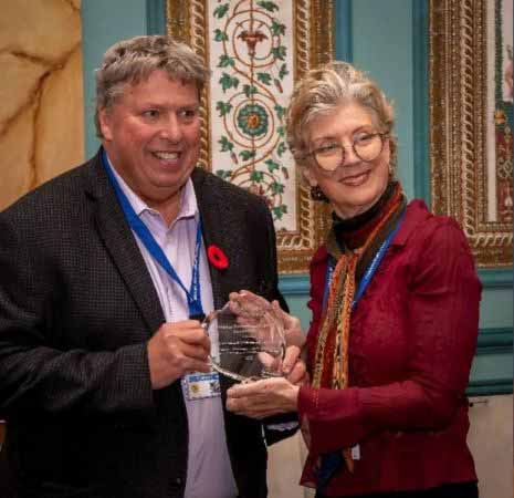 CRVA President Shane Devenish accepts an award from Care Camps Foundation Executive Director Gwynn Sullivan.