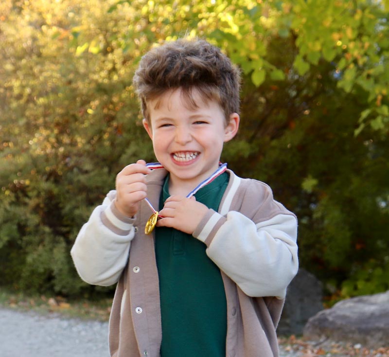 Little boy smiling with a medal around his neck